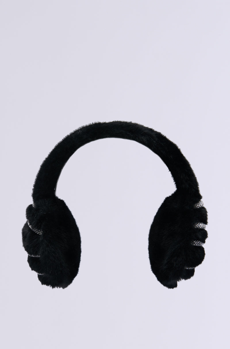 The NOT SO TYPICAL FAUX FUR EAR MUFFS, shown against a light gray background, boast a black plush design ensuring warmth and comfort. The headband and ear covers feature uniform fluffy material, merging style with coziness.