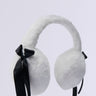 The GIRLY POP FAUX FUR EAR MUFFS feature plush faux fur and black satin ribbon accents on each side, making them an essential cold weather accessory against a light background.