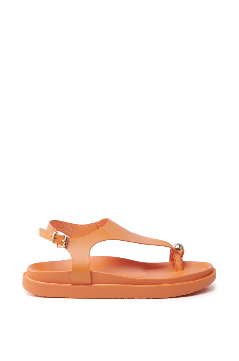 The AKIRA NICCOLO ORANGE FLAT SANDAL is a faux leather sandal with an open almond toe, adjustable ankle strap, and small metallic embellishment. It is elegantly photographed against a plain white background.