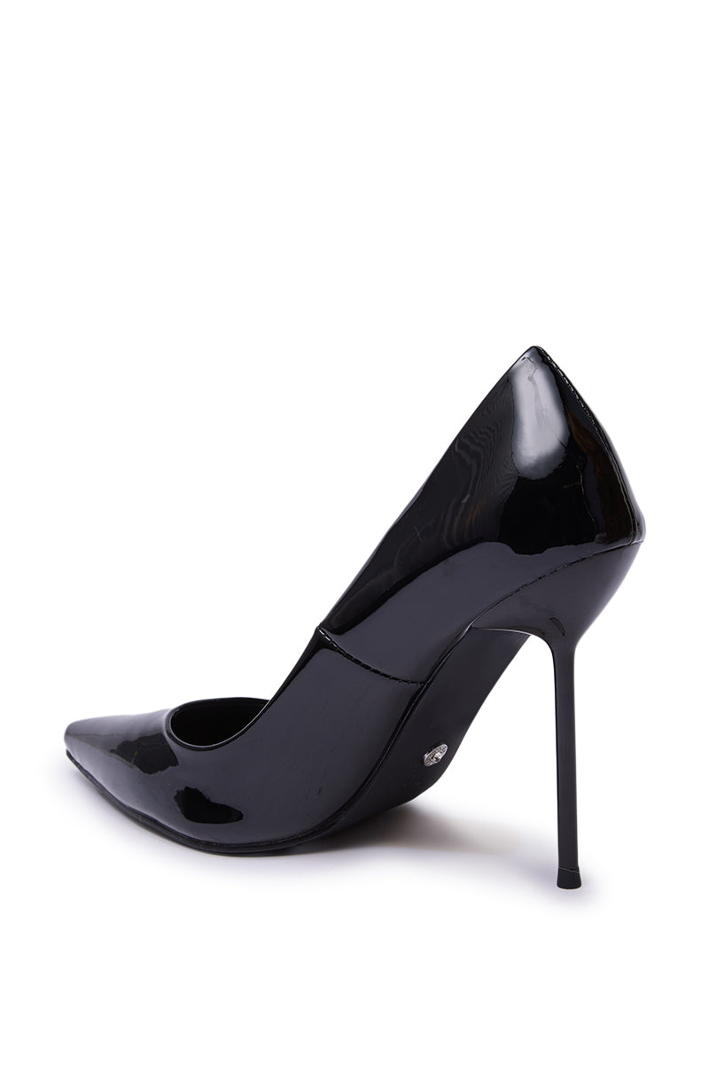 The AZALEA WANG NIKOMEDES Black Patent Stiletto Pump features a glossy faux patent leather finish, metallic detail near the sole, and a pointed toe heel, shown side view.