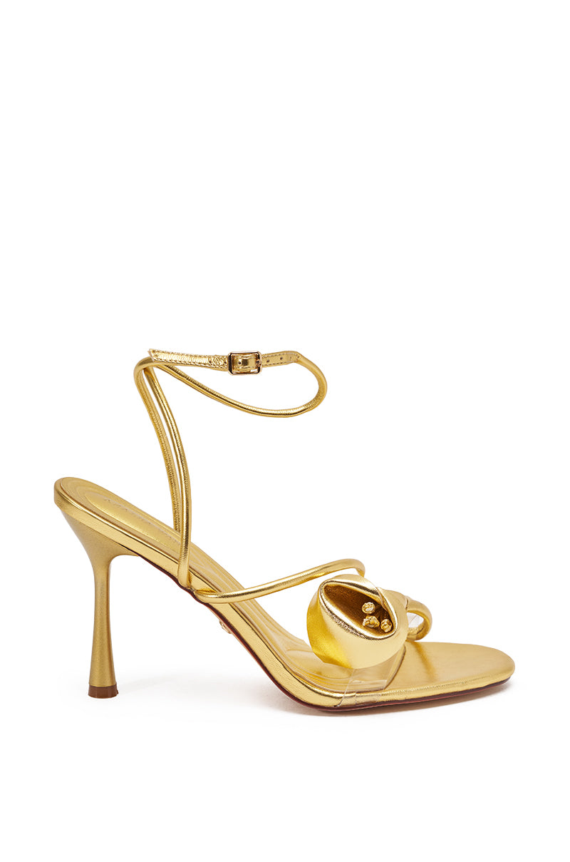 The AZALEA WANG NILO GOLD METALLIC FLORAL DECALE STRAP STILETTO SANDAL features thin ankle and toe straps, a striking floral accent front, sleek stiletto heel, and shiny gold metallic finish for a glamorous touch. 3