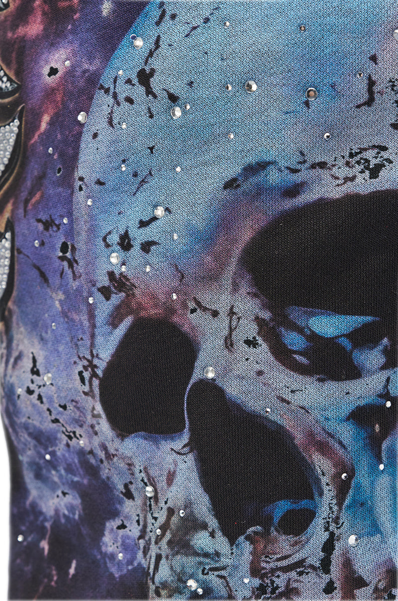 A close-up of the AKIRA GOLD NINE LIVES GRAPHIC OPEN TOE WEDGE BOOT featuring a blue and purple galaxy print, a bold black skull, and sparkling rhinestones—perfect for making a statement.