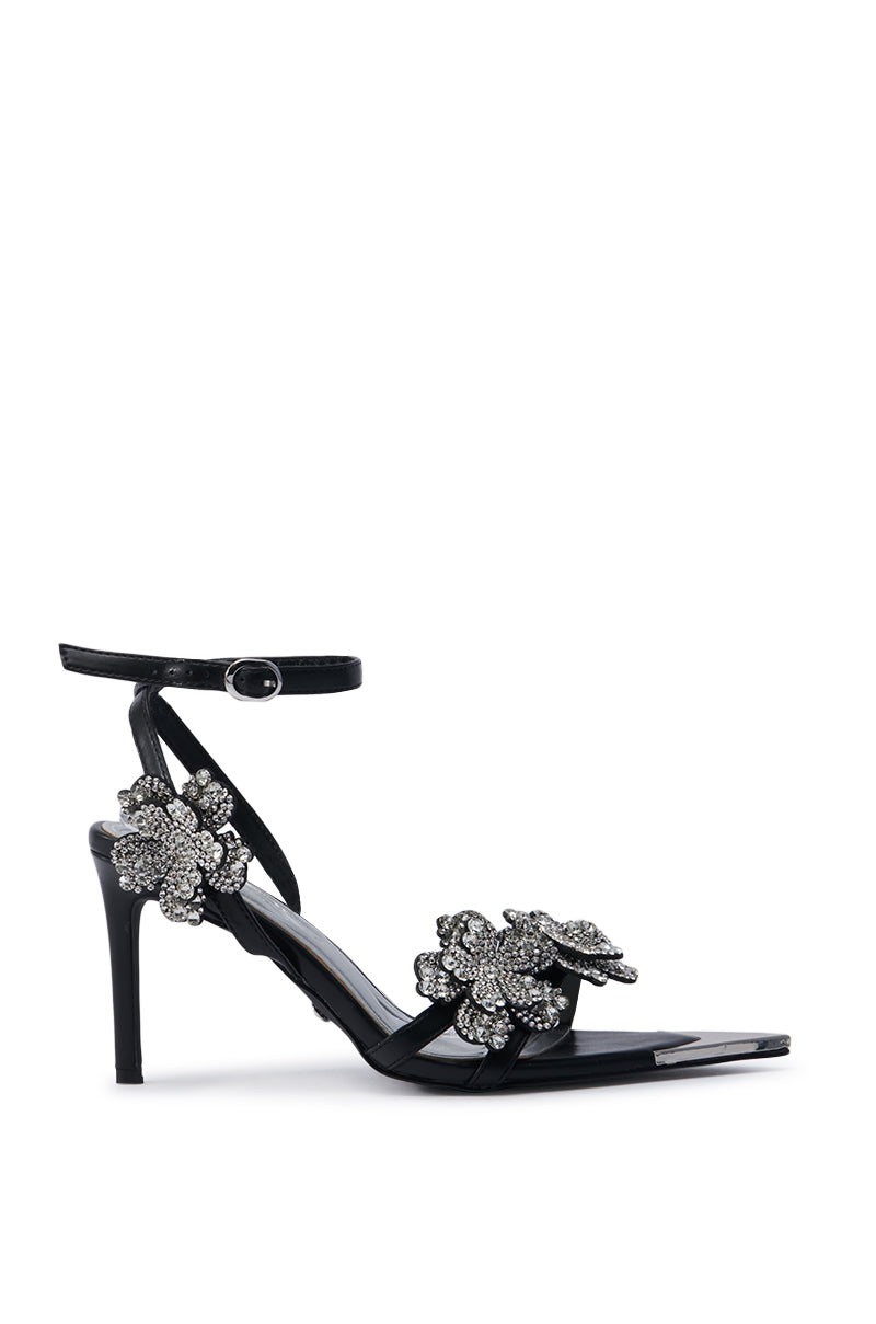 Introducing the AZALEA WANG NJEMA FLOWER EMBELLISHED STILETTO SANDAL: A stylish black high-heeled sandal featuring an ankle strap adorned with intricate floral appliques embellished with rhinestones. This elegant shoe showcases a slim heel and metallic floral designs enhanced with sparkling details, all while offering a comfort cushion insole for maximum ease.