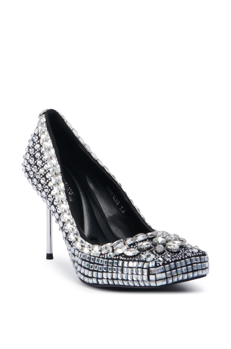The AZALEA WANG NOOMI BLACK PUMP captivates with its reflective silver and black square tiles, featuring a pointed toe adorned with a floral motif. Its slender, rhinestone stiletto heel brings an elegant flair to this glamorous black pump.