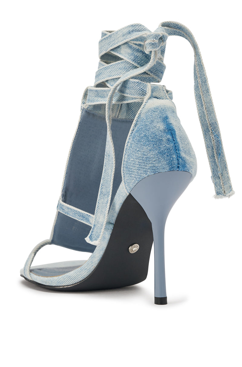 The AKIRA GOLD NORMA JEAN DENIM STRAPPY STILETO SANDAL features a light blue open toe, wrap-around ankle straps with frayed ends, and a slim glossy denim stiletto heel for casual-chic style. 5