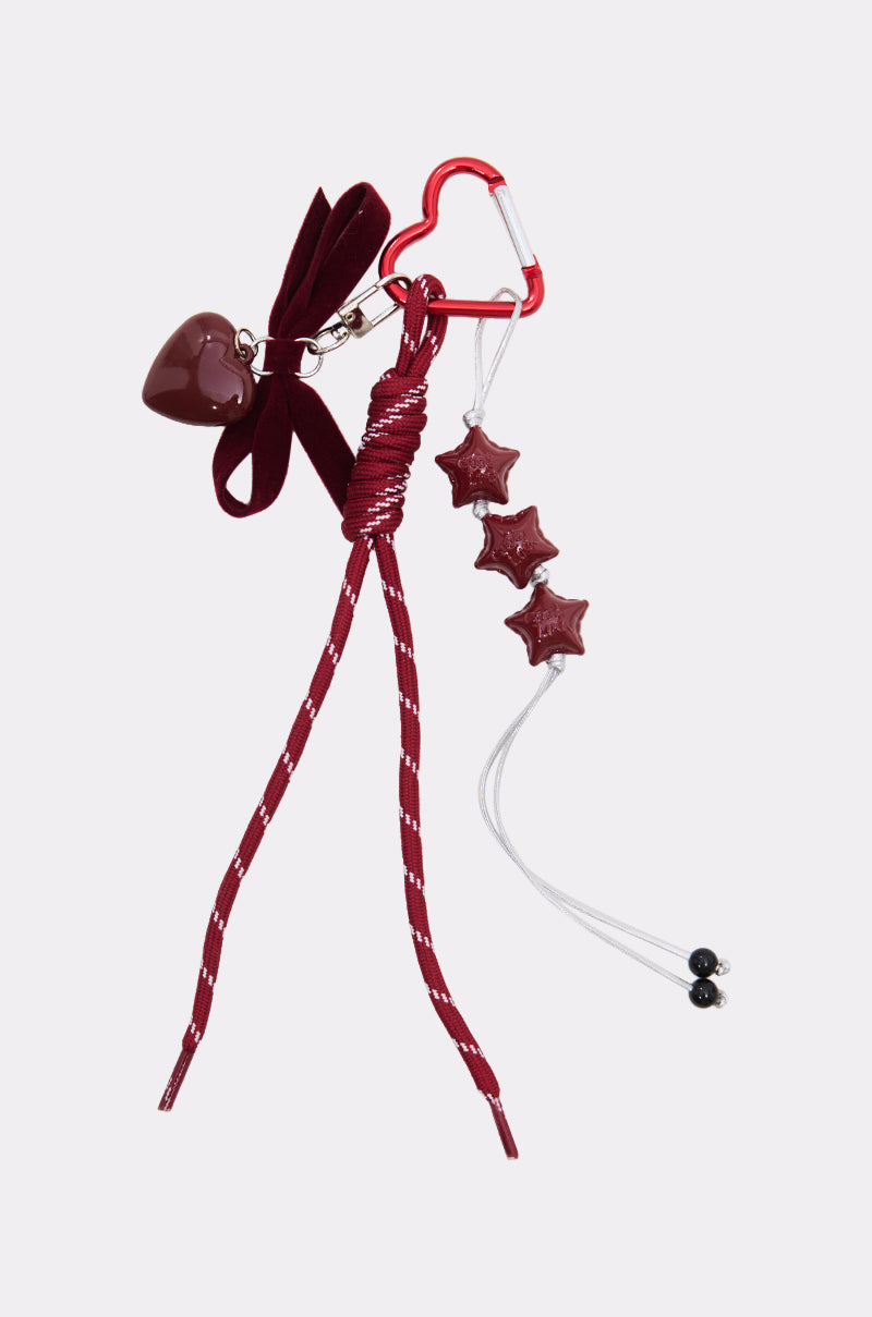 The ULTIMATE KEYCHAIN SET features a red heart-shaped charm, a matching carabiner, maroon bow, striped cord, and maroon star beads—ideal for fans of novelty keychains and bold accessories.