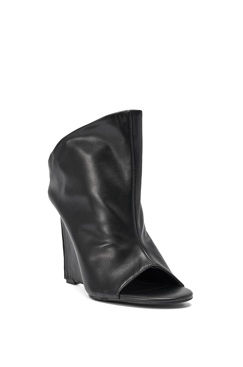 The AZALEA WANG NOVIS BLACK PU WEDGE BOOTIE is a black peep toe ankle boot in smooth PU with a slouched, asymmetrical design and an angular wedge heel, displayed on a white background. 5