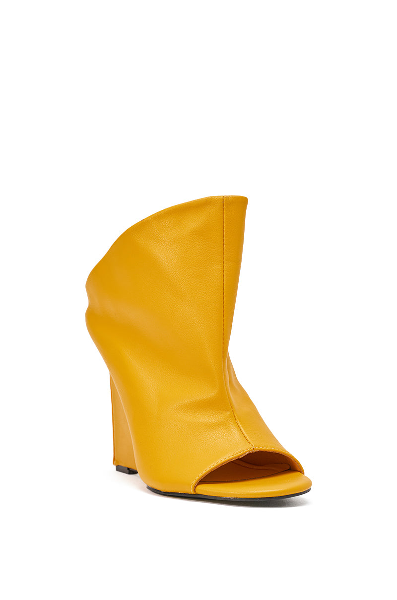The AZALEA WANG NOVIS YELLOW WEDGE BOOTIE is a bright yellow peep toe leather bootie with a sculptural slouchy design and comfort cushion insole, shown angled against a white background. 4