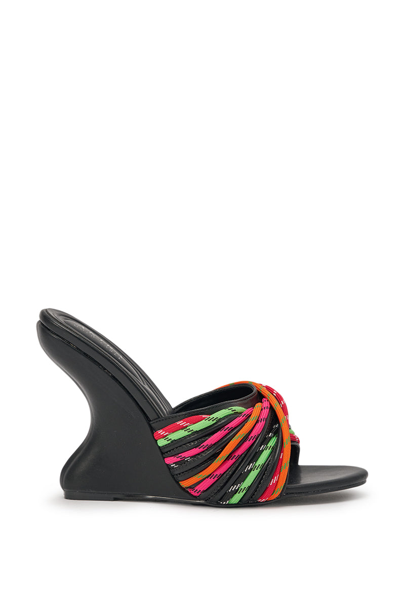 The AKIRA GOLD NOWITZKI MULTI WEDGE AND SHOE LACE SANDAL is a black faux leather sandal with a sculptural wedge heel and vibrant red, pink, green, and orange rope straps crisscrossing the top. 3