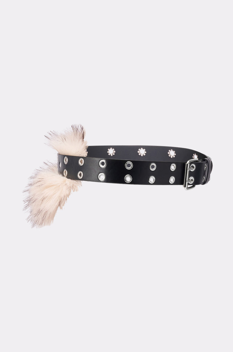 The IN THE SNOW FAUX FUR BELT features black faux leather with silver eyelets, floral studs, and a white faux fur accent, finished with a sleek silver adjustable buckle. Displayed on a plain light background. 4