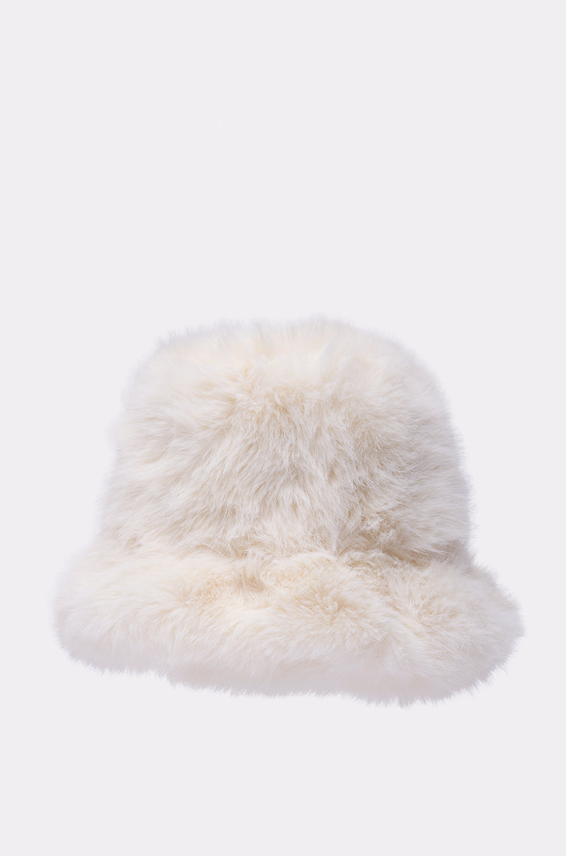The BABY IT'S COLD OUTSIDE FAUX FUR BUCKET HAT IN IVORY is showcased against a plain light background, making it an essential addition to your winter wardrobe.