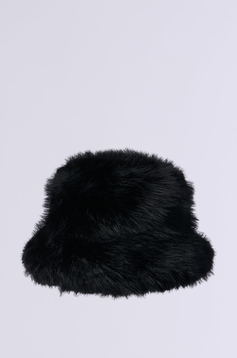 The APRES SKI Faux Fur Bucket Hat in black stands out against a plain gray background, making it an essential piece for cold weather attire.