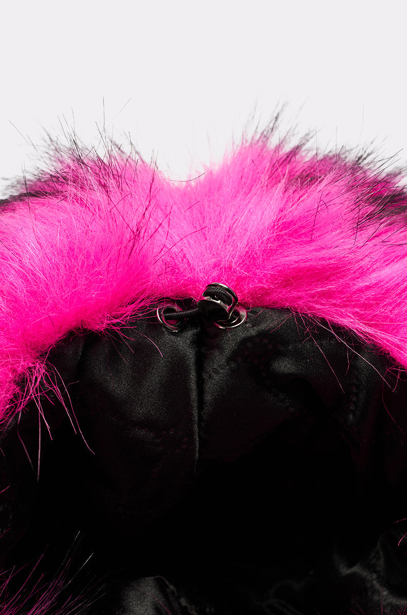 Close-up of the HOTTIE FAUX FUR BUCKET HAT—black with a bright pink faux fur trim, oversized style, and a black drawstring with metal eyelets and center toggle. 6