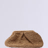 The OUT OF OFFICE OVERSIZED RAFFIA CLUTCH is a beige woven straw bag with a textured surface and soft, gathered design, shown against a plain light gray background.