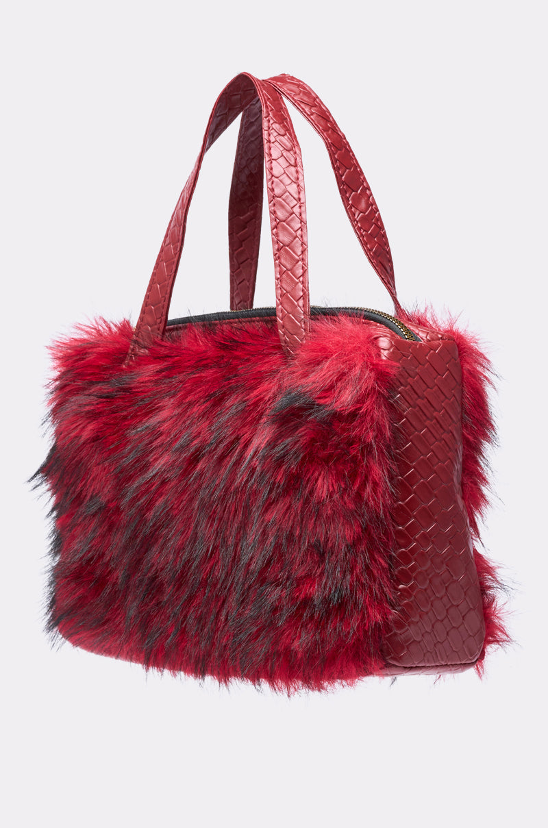 The TRUDY FAUX FUR PURSE features a fluffy red and black faux fur body with red snakeskin-embossed trim on the handles and sides, displayed against a plain light background. 2