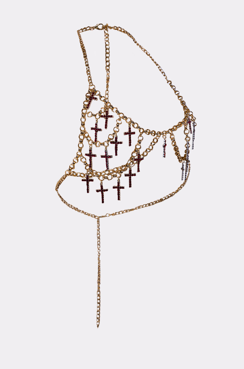 The HOLY CROSS BODY CHAIN is a gold halter top harness featuring an asymmetrical design and multiple dangling rhinestone cross pendants, showcased as bold body jewelry on a clean white background.