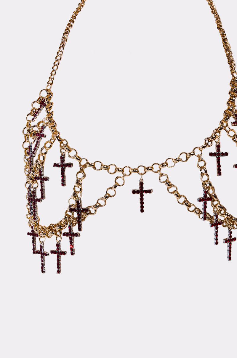 The HOLY CROSS BODY CHAIN is a gold chain necklace featuring multiple rhinestone cross pendants with purple gemstones, beautifully arranged along the chain and shown against a white background—a striking piece of body jewelry. 8
