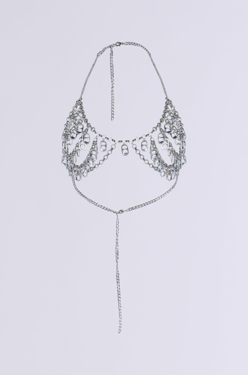 The POPPIN TAGS BODY CHAIN is a delicate silver body chain with intricate metallic loops, elegantly draping over the shoulders and chest. It features a central vertical chain and an adjustable halter neckline, all set against a plain gray background.