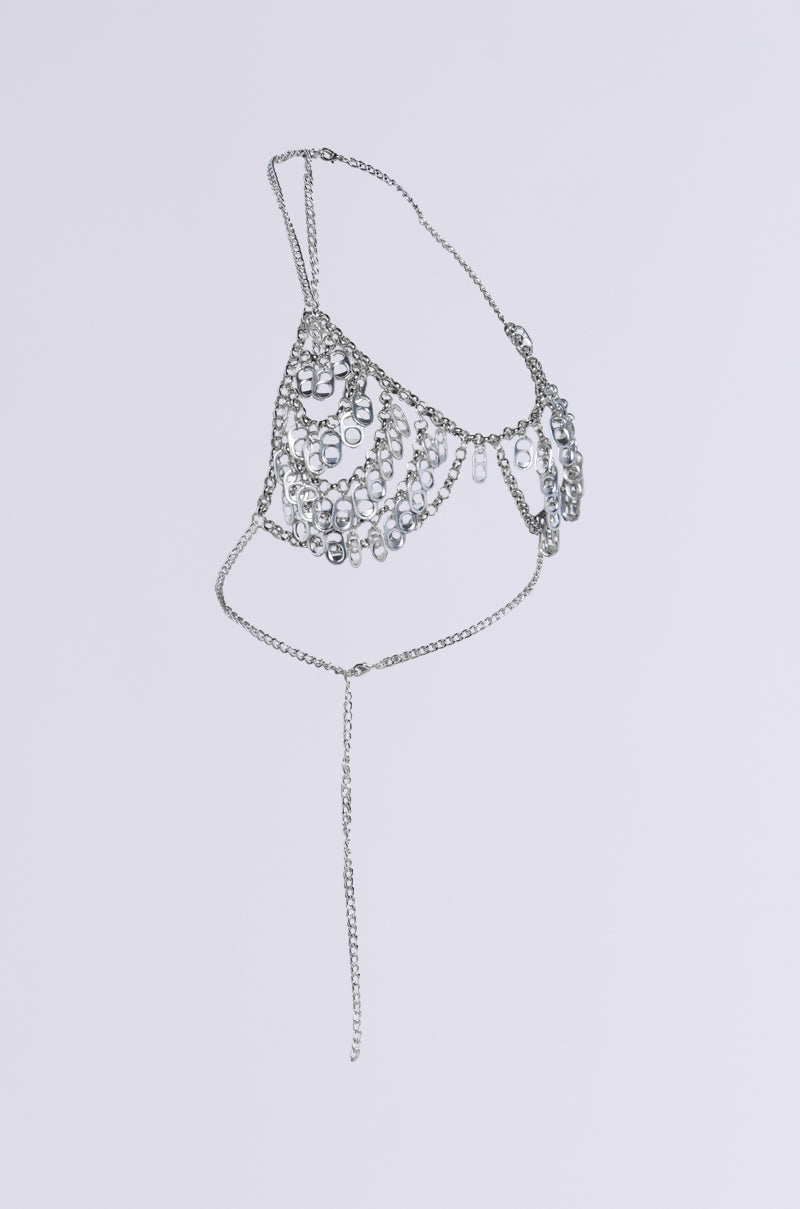 The POPPIN TAGS BODY CHAIN showcases delicate silver construction adorned with clear crystals in a triangular pattern. It features an adjustable halter neckline and a long center chain, all set elegantly against a plain white background.