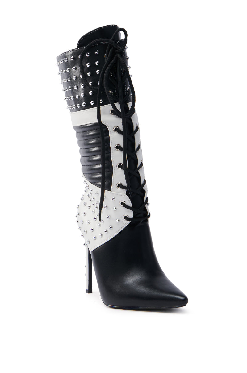 The AZALEA WANG OCTOBI BLACK AND WHITE STILETO BOOT features a faux leather upper with laces, silver studs, quilted textures on the shaft and heel, and contrasting panels at the ankle. Its pointed toe completes the sleek design.