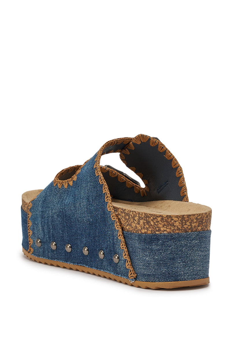 The AZALEA WANG OHKAY DENIM FLAT PLATFORM SANDAL features a denim upper with tan stitching, metal studs on the side, a cushioned footbed, and a thick wedge heel wrapped in denim for stylish comfort. 5