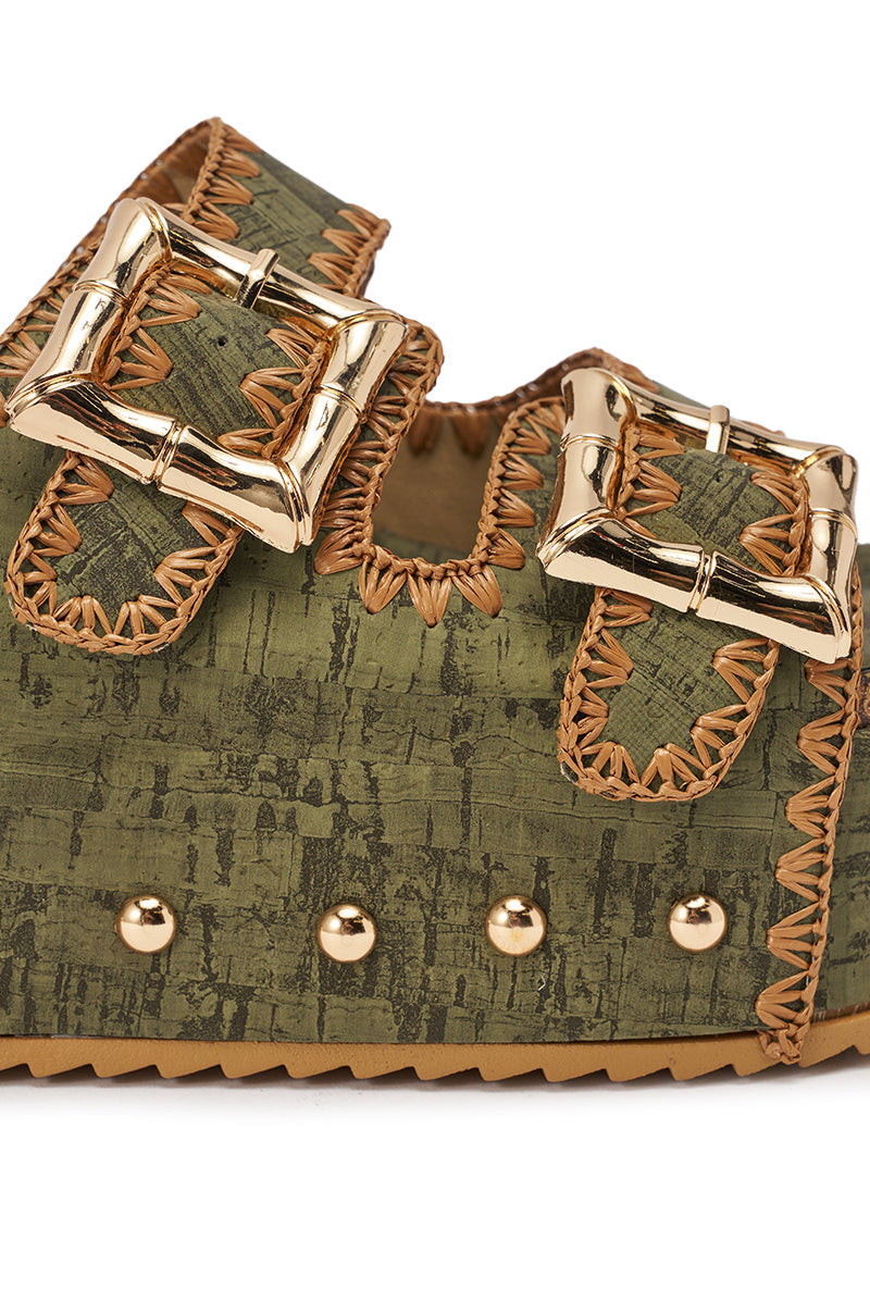 Close-up of the AZALEA WANG OHKAY GREEN FLATFORM STUD EMBELLISHED SLIP ON SANDAL, featuring gold buckles, tan edge stitching, side gold studs, faux leather upper with a cork-like pattern, and a ridged rubber sole. 6