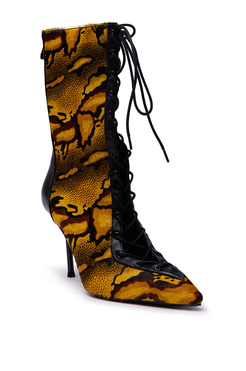 The AZALEA WANG OLIVERS YELLOW STILETTO LACE UP BOOTIE features a pointed toe, bold yellow and black snakeskin pattern, and black leather accents on the front and heel.