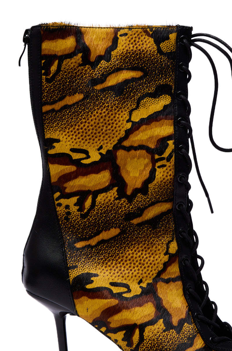 The AZALEA WANG OLIVERS YELLOW STILETTO LACE UP BOOTIE showcases a yellow and black animal print with faux fur texture, black leather trim, and a bold stiletto heel.
