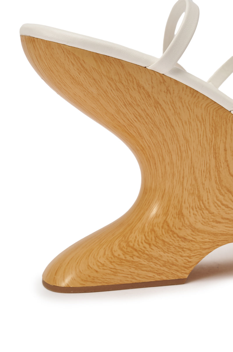Close-up of the AZALEA WANG ONNI WHITE STRAPPY UPPER WOOD WEDGE, showing its sculptural wedge sandal design with a smooth, light wood-grain heel and a white faux leather upper strap, viewed from the side. 9