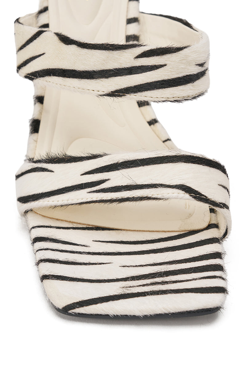 The AZALEA WANG OPHIEL ZEBRA PONY HAIR SANDAL features genuine pony hair in a zebra print, two foot straps, a statement heel, and a square toe for standout style. 6