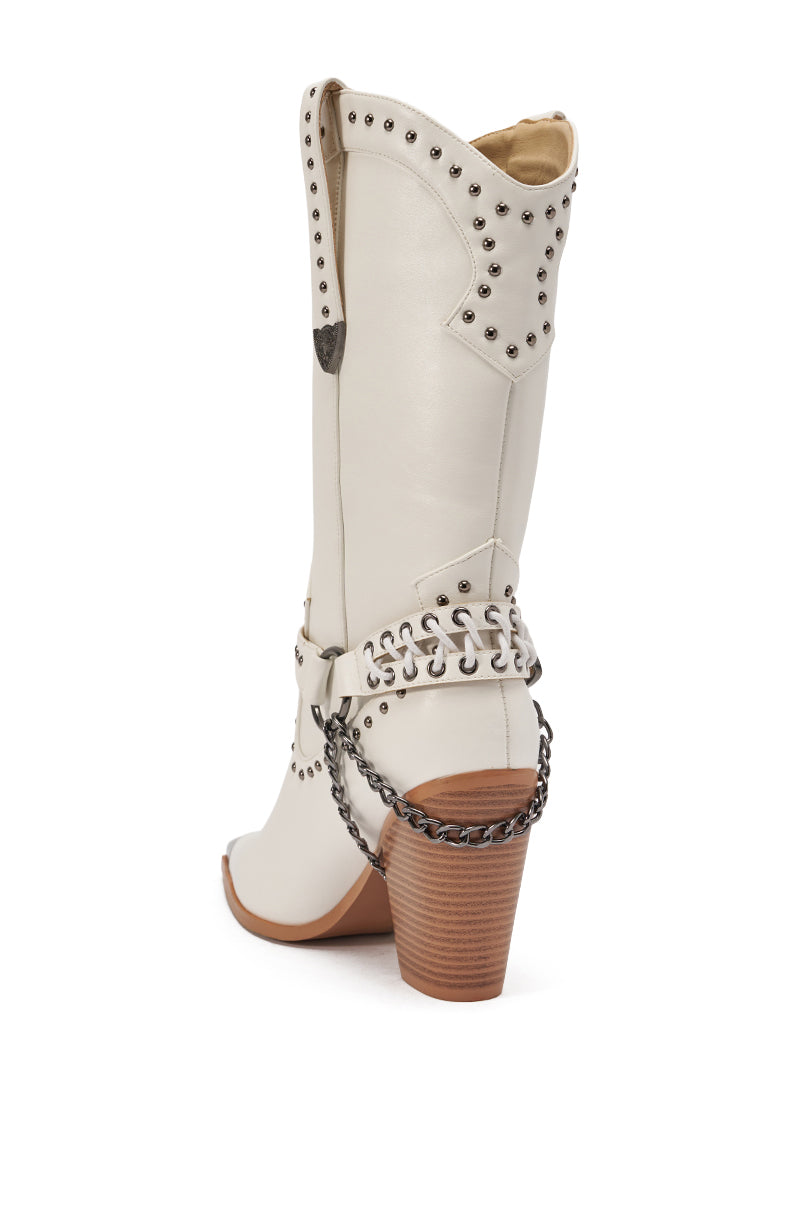 The AZALEA WANG OSBORN WHITE WESTERN BOOTIE features white studs, a decorative chain around the heel, and a brown stacked wooden heel—shown from the back angle, these mid-calf cowboy boots deliver a standout western look.
