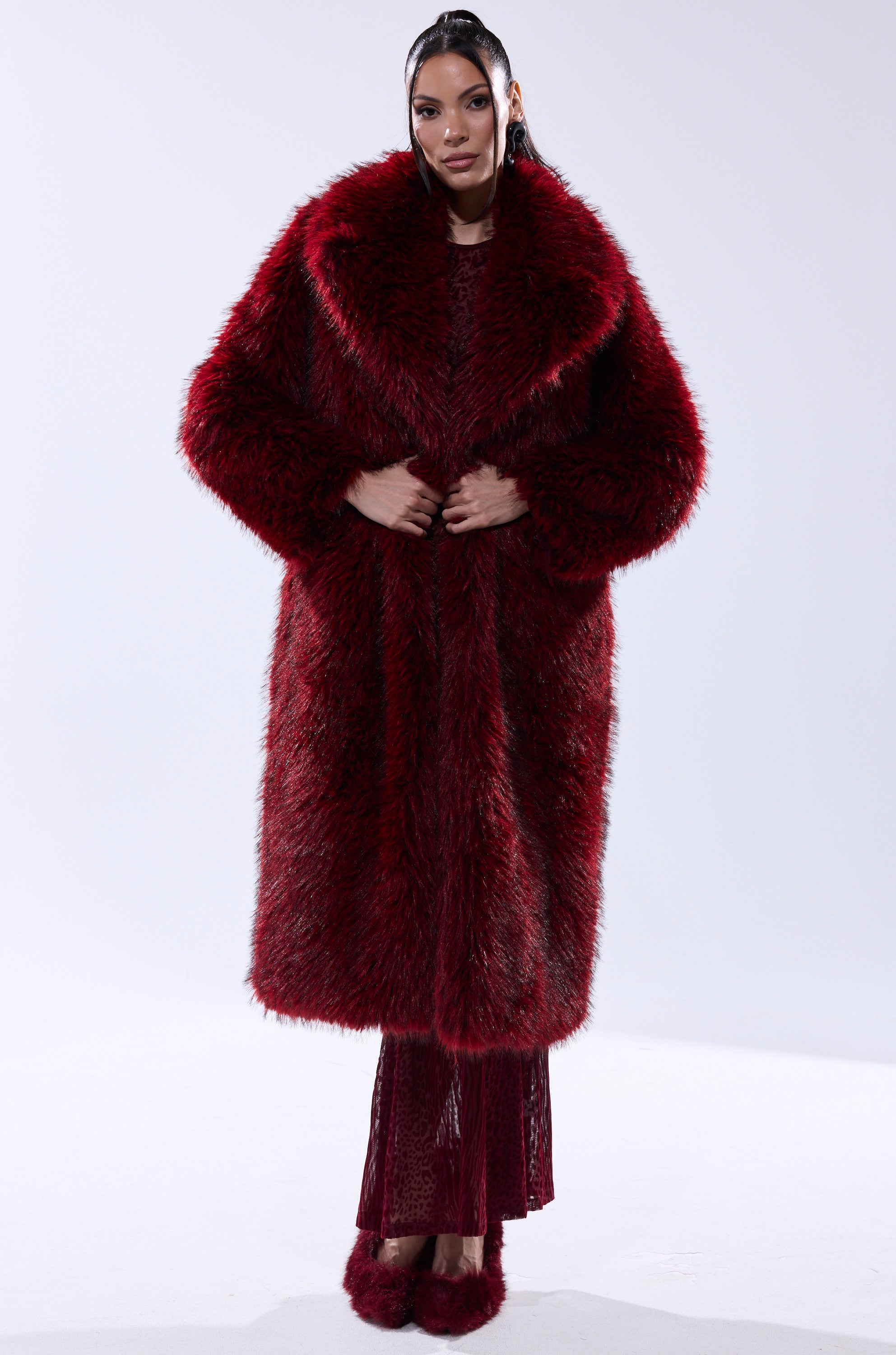 A woman wearing the OSLO FAUX FUR COAT IN RED MULTI.