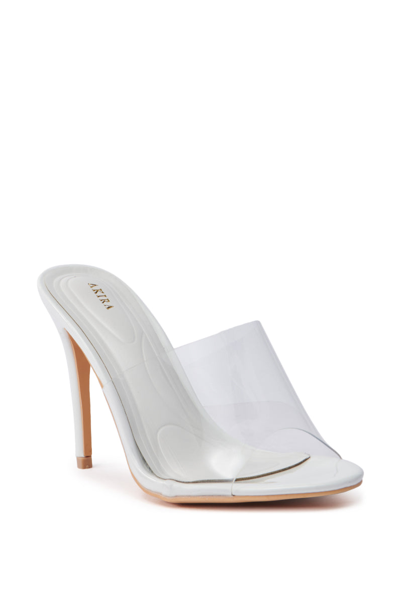 The AKIRA OSWEGO WHITE SLIP ON SANDAL is a single high-heeled shoe with a translucent PVC vamp and beige insole, featuring a sleek stiletto heel for an elegant look suitable for any occasion.