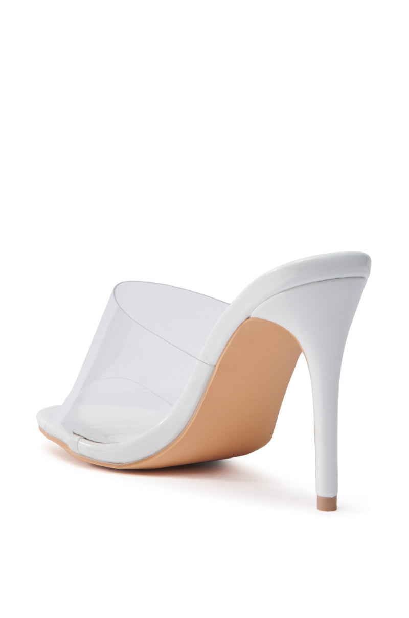 The AKIRA OSWEGO WHITE SLIP ON SANDAL features a translucent PVC vamp and white sole. Its thin stiletto heel enhances elegance, and the open toe design completes its sleek, modern look.