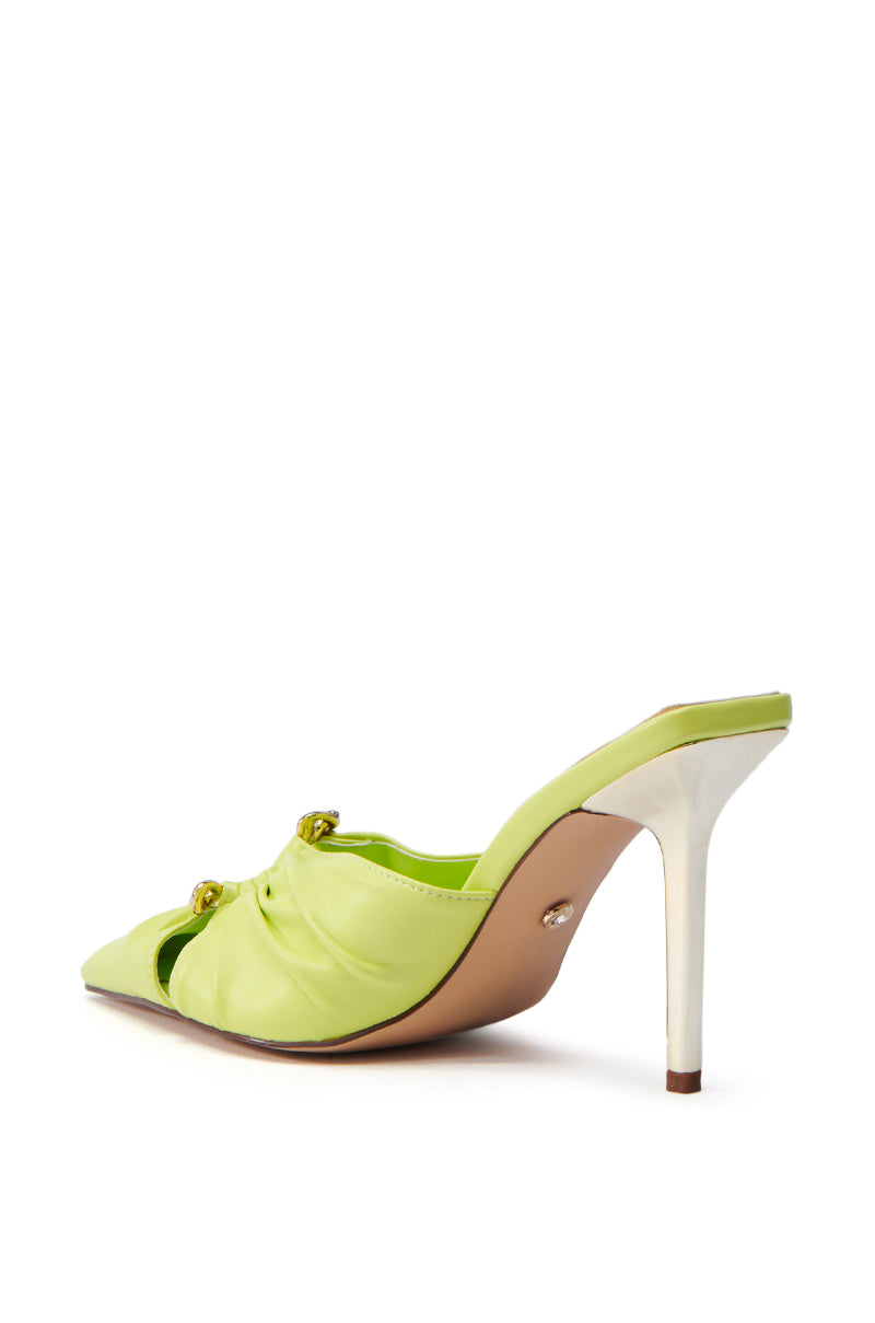 The AZALEA WANG OTZARA yellow stiletto pump features a pointed toe, faux leather upper, white stiletto heel, and gold embellishments. It's shot at an angle to highlight the side and back views against a white background.