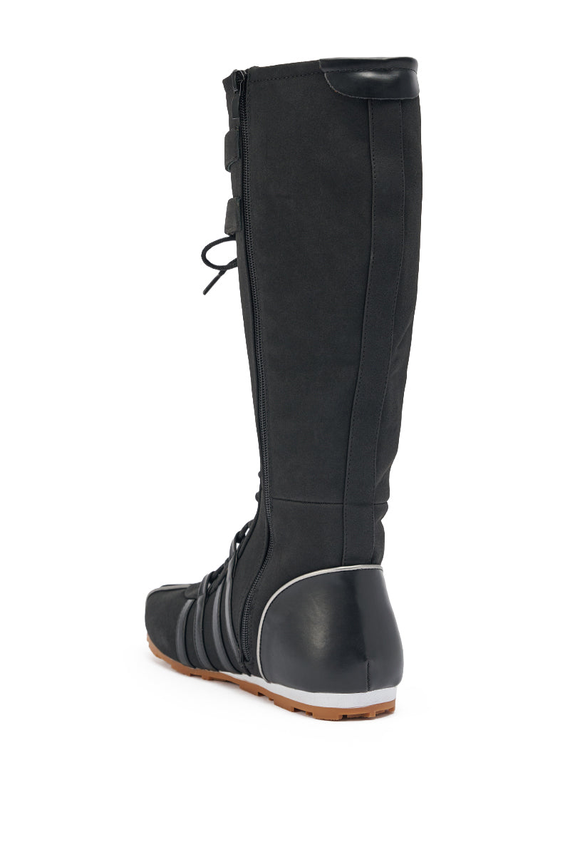 The AZALEA WANG OZZY BLACK FLAT SNEAKER features a tall black lace-up design with a side zipper, reinforced heel, and light brown sole, displayed at an angled rear view on a white background. 5