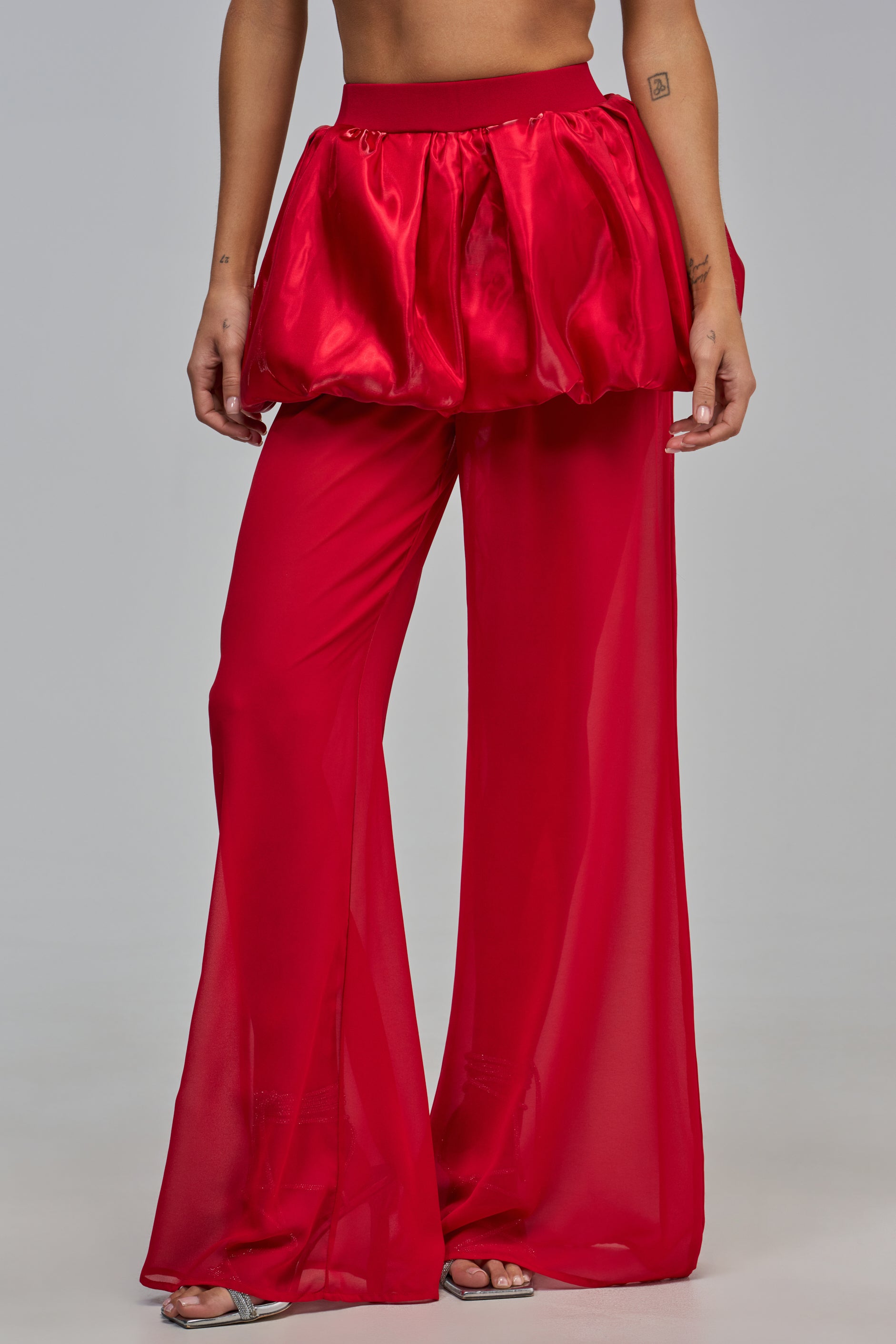 A person wearing IN THE CLOUDS PANT IN RED featuring red bubble pants with a gathered, voluminous skirt overlay at the waist.