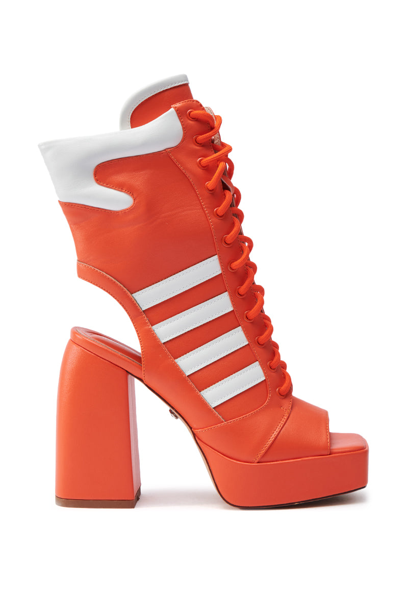The AZALEA WANG PAMINA ORANGE CHUNKY SANDAL is a vibrant orange faux leather high-heeled shoe, featuring white accents and laces, an open toe, block heel, and unique side cut-out detail.