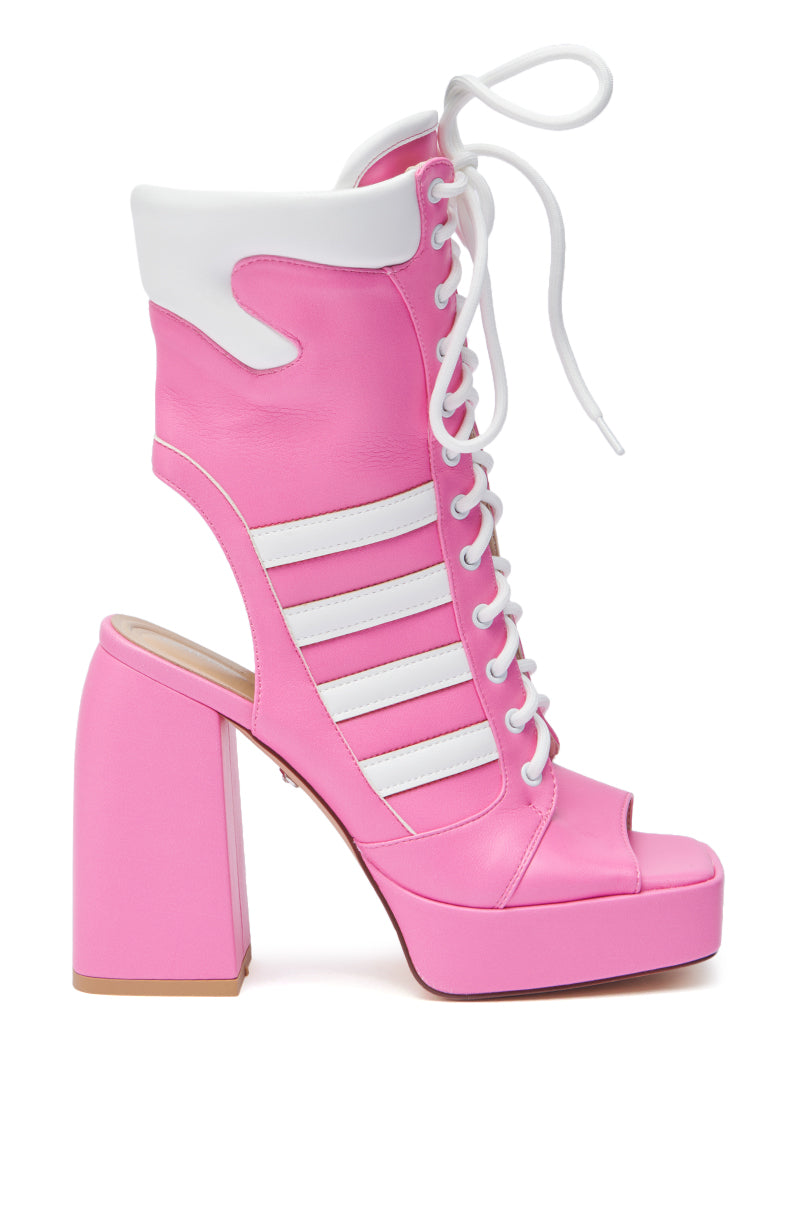 The AZALEA WANG PAMINA PINK OPEN TOE SPORTY BOOTIE features bright pink faux leather, white laces, sporty cut-out stripes, a white padded collar, a chunky high heel, an open toe, and a playful heel cut-out for a bold look. 3