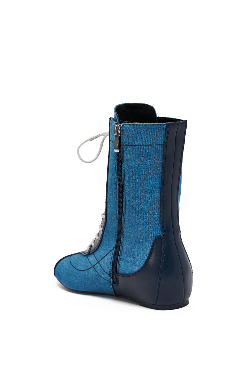 A side view of the AZALEA WANG PASSER NAVY FLAT SNEAKER shows dark blue trim, white laces, a side zipper, and a flat sole in a sleek denim design.