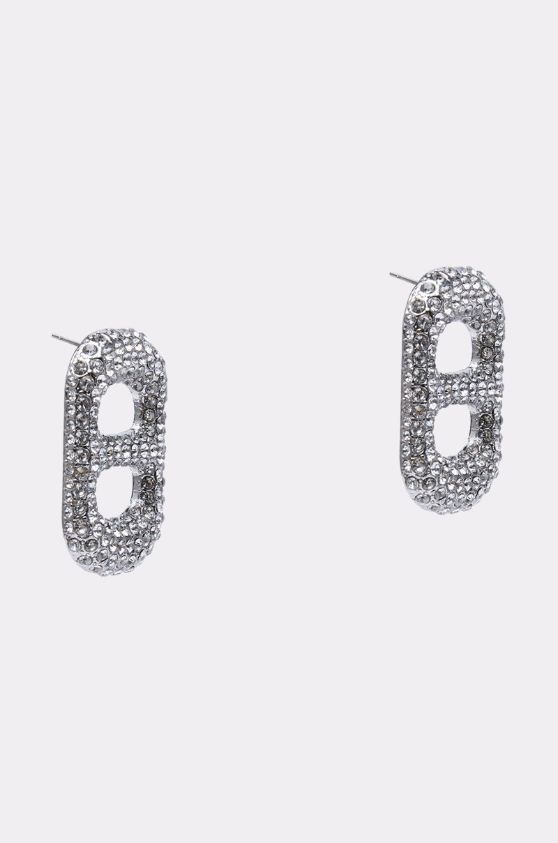The POP IT EARRING is a pair of silver-tone, oval-shaped earrings encrusted with clear rhinestones, each featuring two open oval cutouts in the center, displayed on a plain light background. 2