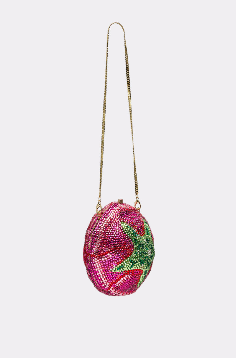 The NOT THAT KIND OF ROSE PURSE, a small, round novelty hardshell handbag shaped like a tomato and covered in pink, red, and green crystals with a gold chain strap and clasp closure, is photographed on a plain light gray background. 5
