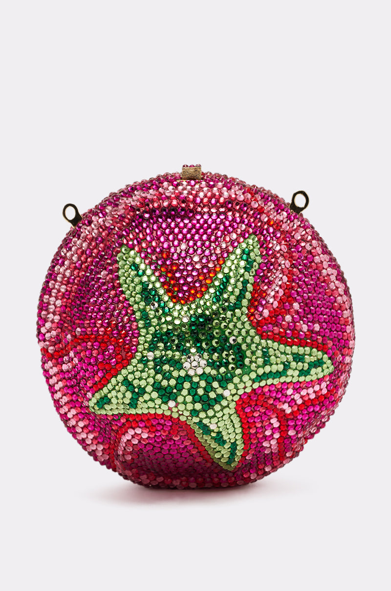 The NOT THAT KIND OF ROSE PURSE is a round, pink rose-shaped hardshell bag with a green and yellow star center, shiny beaded texture, and metal side loops for charm and versatility.