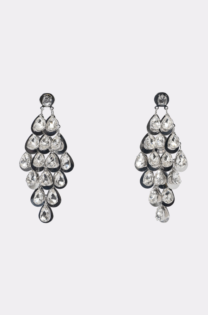 The DAZZLE ME EARRING features statement drop earrings with multiple clear, teardrop gemstones in cascading layers on a dark metal base, shown against a plain light background. 0