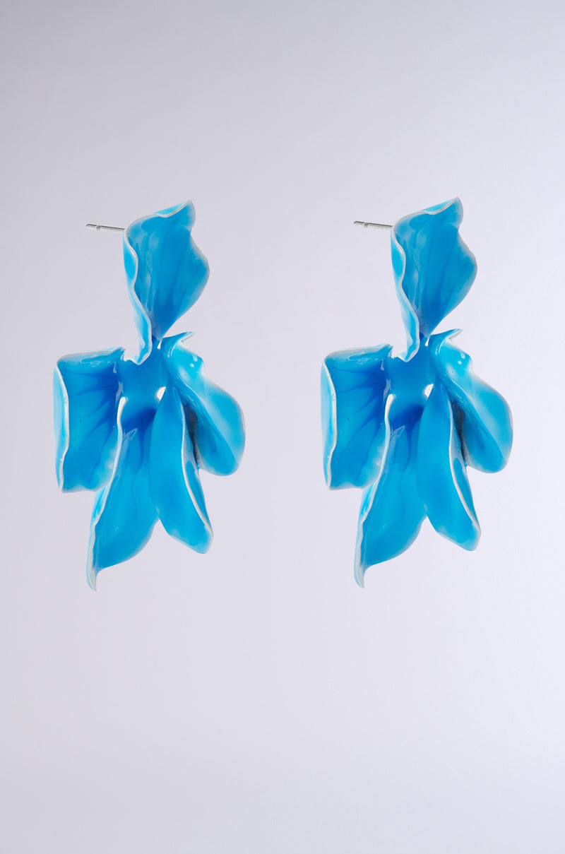 The NO BLUES EARRING showcases a floral silhouette with glossy blue curved petals and subtle textured details, set against a light gray background. 2