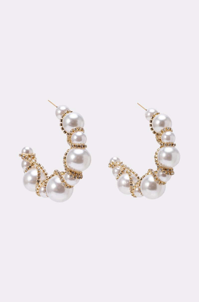 The MIRACLE HOOP EARRING features gold-tone hoops with large and small white faux pearls, accented by delicate gold beads wrapped around the hoops—perfect for a chic statement. Displayed on a light gray background. 0