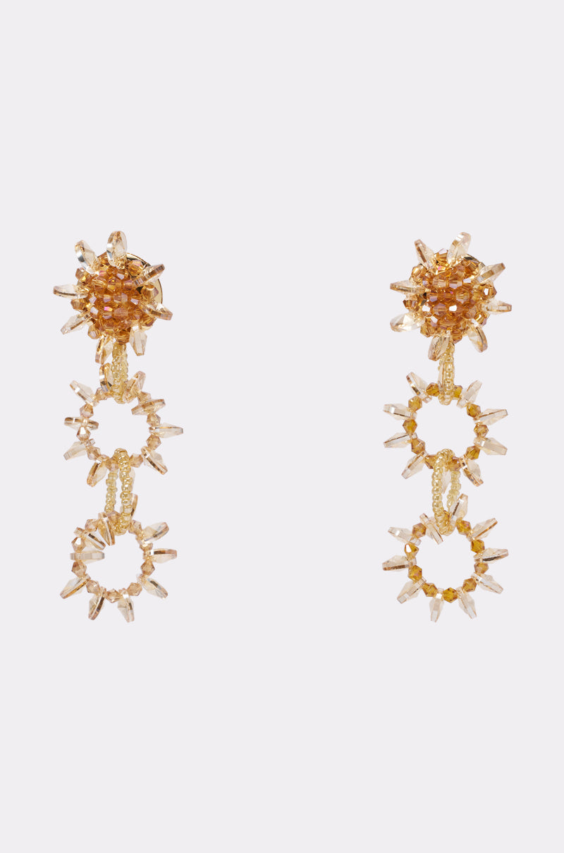 The COME AND GET ME EARRING features gold and crystal beaded drop sunburst designs with three linked circles, embellished with clear and gold-toned crystals—perfect for vacations—shown against a plain white background. 2