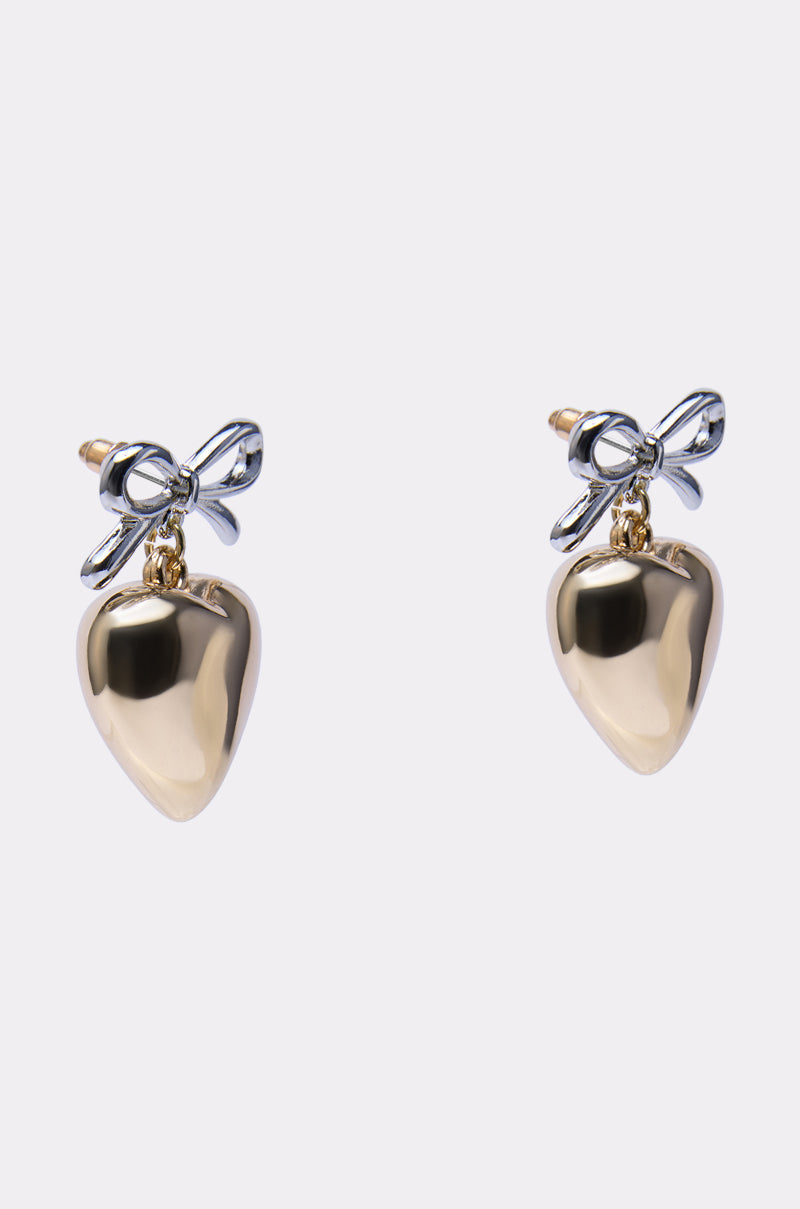 The BIG HEART EARRING features gold heart shapes with shiny silver bow accents at the top, shown against a plain white background. 2