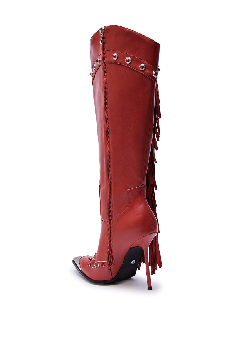 The AZALEA WANG PELAGIANA Red Western Pointed Toe Stiletto Boot features knee-high red leather, silver studs, a pointed toe, side zipper, and decorative back fringe, bringing bold style to classic western boots. Shown on a white background. 6