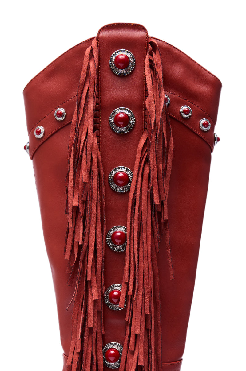 A close-up of the AZALEA WANG PELAGIANA Red Western Pointed Toe Stiletto Boot showcases red faux leather, silver and red conchos, and long leather fringe for classic western flair. 7